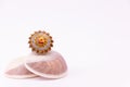 Traditional ring gift concept. Cocktail golden ring on seashell with white background