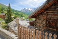 Traditional roofs and a wooden house in Saint Veran village, with mountain range covered with snow and pine tree forests