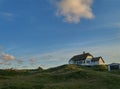 Traditional rural house in the dunes of Vejers Strand Denmark in scenic evening sunlight Royalty Free Stock Photo