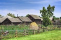 Traditional rural landscape in Russia, haystack, beehives, izba, green grass and blue sky