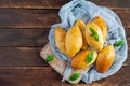 Traditional Russian cabbage pies on wooden background. Baked homemade pirozhki with cabbage. Top view