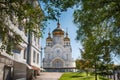 A traditional Russian church with golden domes against a blue sky and a green branch frame. Royalty Free Stock Photo