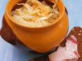 Traditional russian cuisine Sauerkraut in a ceramic barrel pot with break and lard on blue shabby background close up Royalty Free Stock Photo