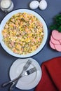 A traditional Russian dish - New Year`s salad Olivier in a large enamel bowl, boiled sausage, eggs and mayonnaise Royalty Free Stock Photo