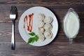 Traditional Russian dumplings, ravioli, pelmeni on a white plate with red sauce and parsley. Dark wooden background Royalty Free Stock Photo