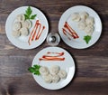 Traditional Russian dumplings, ravioli, dumplings on a white plate with red sauce and parsley. Dark wooden background Royalty Free Stock Photo