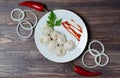 Traditional Russian dumplings, ravioli, dumplings on a white plate with red sauce and parsley. Dark wooden background. Onion rings Royalty Free Stock Photo