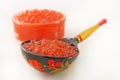 Traditional russian food. Red caviar in Wooden spoon painted in traditional style Khokhloma. Royalty Free Stock Photo