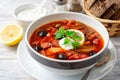 Traditional Russian meat soup Solyanka in bowl on rustic wooden table