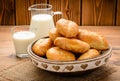 Traditional russian pastry piroshki and milk on wooden table.