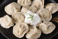 Traditional russian pelmeni, ravioli, dumplings with meat on black background. Top view