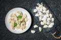 Traditional russian pelmeni, ravioli, dumplings with meat on black concrete background. Top view Royalty Free Stock Photo