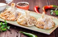Traditional russian pelmeni, ravioli, dumplings with meat in plate on wooden background. Parsley, sour cream and spices Royalty Free Stock Photo