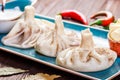 Traditional russian pelmeni, ravioli, dumplings with meat in plate on wooden background. Parsley, sour cream and spices Royalty Free Stock Photo