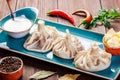 Traditional russian pelmeni, ravioli, dumplings with meat in plate on wooden background. Royalty Free Stock Photo