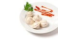 Traditional Russian pelmeni, ravioli, dumplings on a white plate with red sauce and parsley. White background Royalty Free Stock Photo