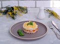 Traditional Russian salad Mimosa with boiled pink salmon, carrots, onions and eggs on a gray concrete background Royalty Free Stock Photo