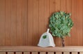 Traditional Russian Sauna Accessories on a Wooden Shelf. Bath Hat with a Leaf and Green Birch Broom Royalty Free Stock Photo