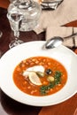 Traditional Russian soup Solyanka with cabbage, olives, lemon and capers on wooden table at restaurant