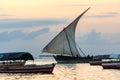 Traditional sailing dhow heading out to sea at dusk on a calm evening ocean Royalty Free Stock Photo