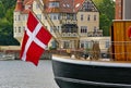 Traditional sailing ship with large Danish national flag hanging from the stern in the harbor of Sonderborg, Denmark