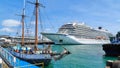 A traditional sailing ship and a modern cruise liner in port