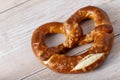 Traditional bavarian salty bread pretzel closeup on rustic wood