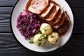 Traditional Sauerbraten dish with potato dumplings and red cabbage close-up. German cuisine. horizontal top view