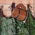 Traditional Sauna Accessories. wooden mug, birch and oak brooms on the background of a wooden wall Royalty Free Stock Photo