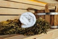 Traditional sauna detail and accessories. White towel, broom and wooden bucket in the sauna.