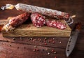 Traditional sausage and sausage with mold. Sliced sausage salami and  knife on wooden board with spices. Royalty Free Stock Photo