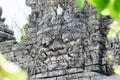 Traditional scary looking Bali island stone sculpture on ancient wall