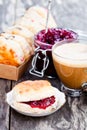 Traditional scone with raisins filled raspberry jam and cup of