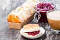 Traditional scone with raisins filled raspberry jam and cup of