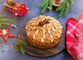 A traditional Scottish Christmas fruit Dundee cake with a mix of dried fruits, decorated with peeled almonds on a wooden board on