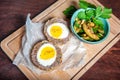 Traditional Scottish meat cutlet with boiled eggs, cucumber and fresh parsley