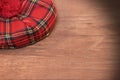 Traditional Scottish Red Tartan Bonnet on Wood Board Royalty Free Stock Photo