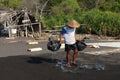 Traditional sea salt production on on the volcanic black sand, B