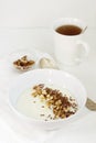 Traditional semolina porridge with butter, nuts and flax seed. A useful breakfast of porridge and tea. Rustic style. Royalty Free Stock Photo