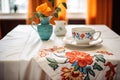 traditional setting with fine china on a floral embroidered cloth