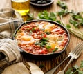 Traditional shakshuka dish served in a cast iron pan on wooden table