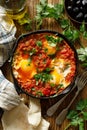 Traditional shakshuka dish served in a cast iron pan on wooden table