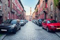 Traditional, silesian district Nikiszowiec. Renovated, old, brick block houses, cobblestone street, cars parked on the street,