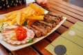Traditional slovenian cuisine, meat kebab - chevapchichi - with french fries. Selective focus Royalty Free Stock Photo