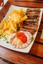 Traditional slovenian cuisine, meat kebab - chevapchichi - with french fries. Selective focus Royalty Free Stock Photo