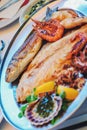 Traditional slovenian cuisine, mixed grilled fish and seafood with garlic oil. Selective focus