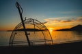 Traditional small net for catching crabs or fish against a beautiful sunset on the sea