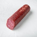 Traditional smoked salami sausage with spices, square format, on white stone table background Royalty Free Stock Photo