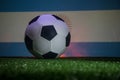 Traditional soccer ball on soccer field. Close up view of soccer ball (football) on green grass with dark toned foggy background. Royalty Free Stock Photo