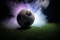 Traditional soccer ball on soccer field. Close up view of soccer ball (football) on green grass with dark toned foggy background. Royalty Free Stock Photo